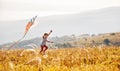 Happy child girl running with kite at sunset outdoors Royalty Free Stock Photo