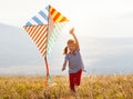 Happy child girl running with kite at sunset outdoors Royalty Free Stock Photo