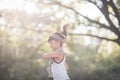 Happy child girl running in the park in summer in nature. warm sunlight flare. asian little is running in a park. outdoor sports
