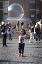 Happy child girl running towards a soap bubble