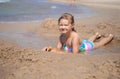 Happy child girl sitting on the beach