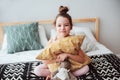 Happy child girl sitting on bed and hugs pillow, waking up in early morning or going to sleep Royalty Free Stock Photo