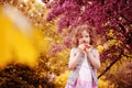 Happy child girl smells flowers at blooming cherry tree in spring garden Royalty Free Stock Photo
