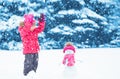 Happy child girl with a snowman on a winter walk Royalty Free Stock Photo