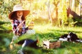 Happy child girl with spaniel dog playing little farmer in autumn garden and picking vegetable harvest Royalty Free Stock Photo