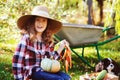 Happy child girl with spaniel dog playing little farmer in autumn garden and picking vegetable harvest Royalty Free Stock Photo