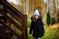 happy child girl standing by wooden house stairs in late autumn garden