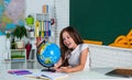 happy child girl study geography with globe at school, learning