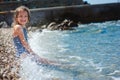 Happy child girl in swimsuit relaxing on the beach and playing with water. Summer vacation at sea. Royalty Free Stock Photo