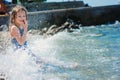 Happy child girl in swimsuit relaxing on the beach and playing with water. Summer vacation at sea. Royalty Free Stock Photo