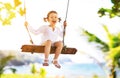 Happy child girl swinging on swing at beach in summer Royalty Free Stock Photo