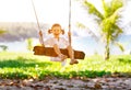 Happy child girl swinging on swing at beach in summer Royalty Free Stock Photo