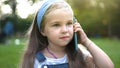 Happy child girl talking on mobile phone in summer park Royalty Free Stock Photo