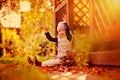 Happy child girl throwing leaves on the walk in sunny autumn garden Royalty Free Stock Photo