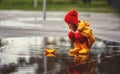 Happy Child Girl With Umbrella And Paper Boat In Puddle In A