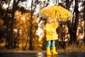 Happy child girl with an umbrella and rubber boots an autumn walk Royalty Free Stock Photo