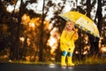 Happy child girl with an umbrella and rubber boots an autumn walk Royalty Free Stock Photo