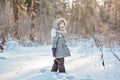 Happy child girl on the walk in winter forest standing and looking out of camera Royalty Free Stock Photo