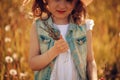 Happy child girl walking on summer meadow with dandelions. Rural country style scene, outdoor activities Royalty Free Stock Photo