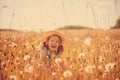 Happy child girl walking on summer meadow with dangelions. Rural country style scene, outdoor activities. Royalty Free Stock Photo
