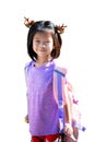 Happy Child Girl wearing reindeer hairpin and carrying backpack, ready for festive school day, Isolated White Background. Royalty Free Stock Photo