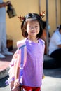 Smiling Asian Kid with Brown Reindeer Hairband to get into Christmas festival.