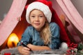 Happy child girl writes a list of gifts and wishes. Letter to Santa Claus on Christmas and New Years Eve Royalty Free Stock Photo