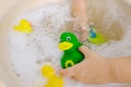 happy child, girl 3 years old plays with rubber green, yellow ducks for swimming Royalty Free Stock Photo