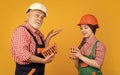 happy child and grandfather bricklayer in hard hat on yellow background Royalty Free Stock Photo