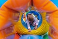 A happy child is having fun on a children`s game inflatable colorful trampoline. A little girl is playing on the playground. A chi Royalty Free Stock Photo