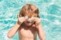 Happy child having fun at swimming pool on summer day. Children playing in blue sea water. Tropical summer vacation Royalty Free Stock Photo