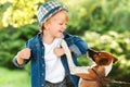 Happy child having fun together with dog outdoors. Little puppy jack russel terrier playing with boy. Boy and dog best friends Royalty Free Stock Photo