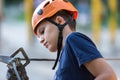 Happy child, healthy teenager in helmet enjoys activity in a climbing adventure rope park