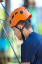 Happy child, healthy teenager in helmet enjoys activity in a climbing adventure rope park