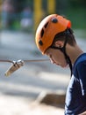 Happy child, healthy teenager in helmet enjoys activity in a climbing adventure rope park on a sunny summer