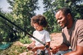 Happy child and his dad fishing on beautiful day outdoors Royalty Free Stock Photo