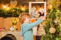 Happy child holding Christmas bauble in front of Christmas tree. Little child boy is happy about the New Year. Christmas Royalty Free Stock Photo