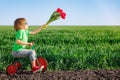 Happy child holding flowers against blue sky background Royalty Free Stock Photo