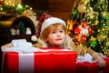 Happy child holding a giant red gift box with both hands. Christmas kids. New year kids. Funny kid holding Christmas