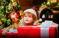 Happy child holding a giant red gift box with both hands. Christmas kids. New year kids. Funny kid holding Christmas