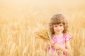 Happy child holding wheat ears