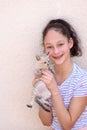 Happy child holds a cat in her arms. Girl caught a little kitty. Royalty Free Stock Photo