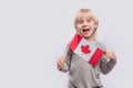 Happy child holds in hands flag of Canada. Emigration to Canada