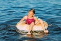 Happy child on an inflatable circle floating on the sea, Summer holidays with children. Swimming equipment and clothing for