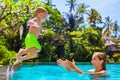 Happy child jump to mother hands in swimming pool Royalty Free Stock Photo