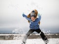 Happy child jumping. Lots of flying snow. Enjoy outdoor games in winter