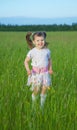 Happy child jumps on green grass in field