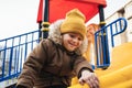 Happy child kid boy playing on a slide on playground in winter in the park Royalty Free Stock Photo