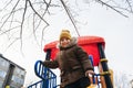 Happy child kid boy playing on a slide on playground in winter in the park Royalty Free Stock Photo