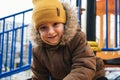 Happy child kid boy playing on a slide on playground in winter in the park Royalty Free Stock Photo